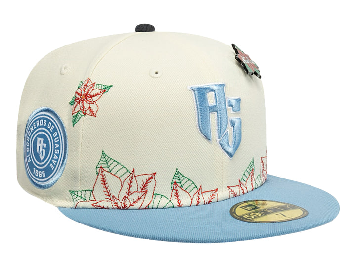 Gorra New Era blanca con visera azul claro y bordados navideños de flores rojas y verdes.