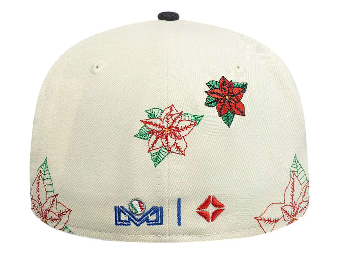 Gorra New Era blanca con visera azul claro y bordados navideños de flores rojas y verdes.