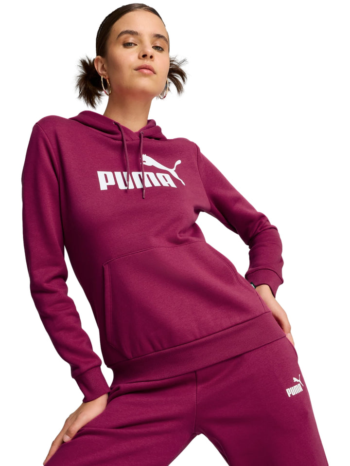 Mujer vistiendo sudadera con capucha y pantalones deportivos color magenta con logotipo de PUMA en blanco.