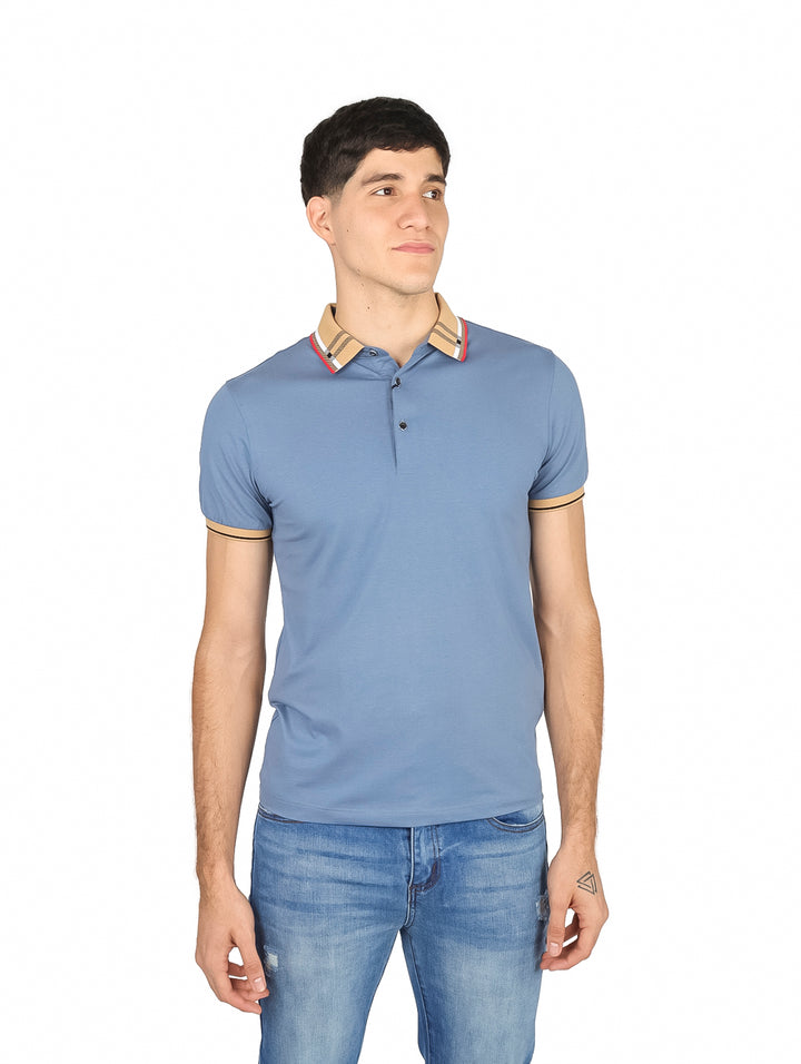 Hombre vistiendo playera polo color azul con detalles en beige y rojo en el cuello y mangas.