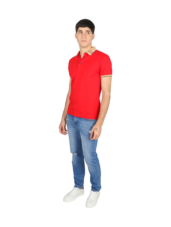 Hombre vistiendo playera polo color rojo con detalles en beige en el cuello y mangas, combinada con jeans azules.