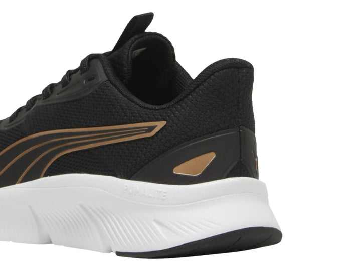 Tenis PUMA FlexFocus Lite Modern en color negro con detalles dorados y suela blanca.