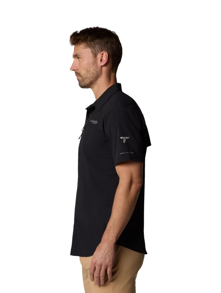Hombre vistiendo una camisa Columbia de manga corta color negro con cuello y botones.