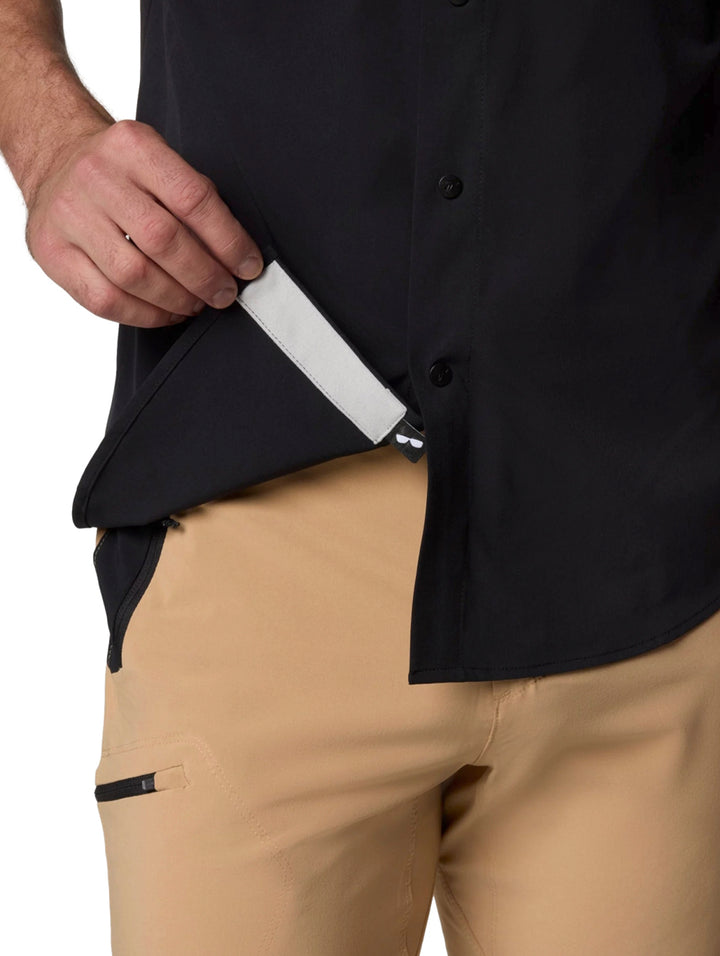 Hombre vistiendo una camisa Columbia de manga corta color negro con cuello y botones.