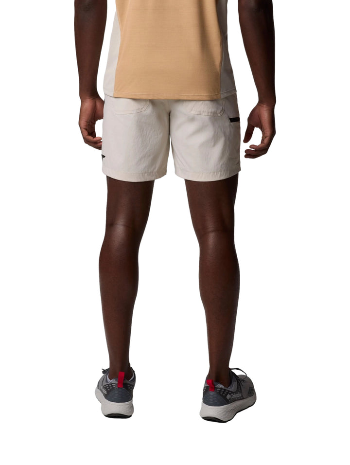 Hombre vistiendo pantalones cortos Columbia color Dark Stone de corte ligero y estilo deportivo.