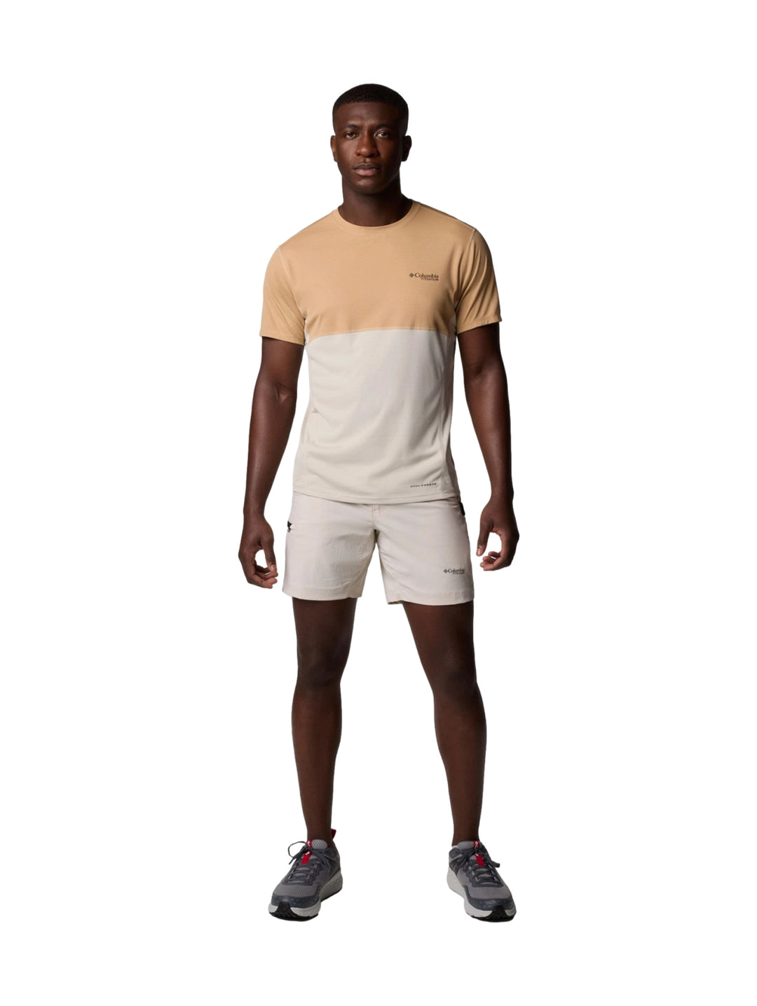 Hombre vistiendo pantalones cortos Columbia color Dark Stone de corte ligero y estilo deportivo.