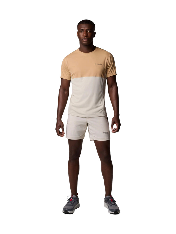 Hombre vistiendo pantalones cortos Columbia color Dark Stone de corte ligero y estilo deportivo.