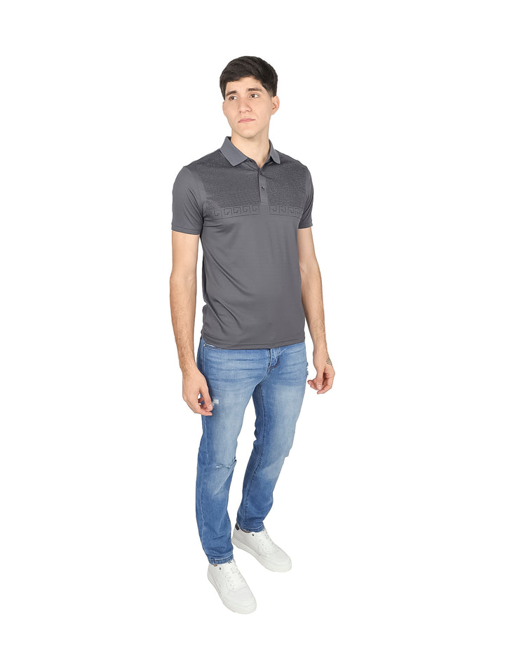 Hombre vistiendo una playera polo de color gris oscuro con detalles texturizados en el pecho.