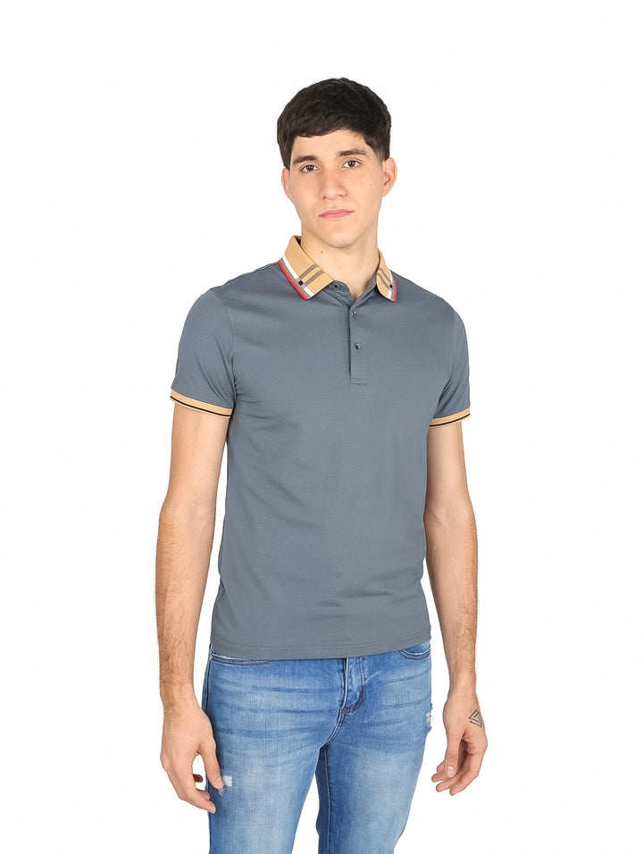 Hombre vistiendo una playera polo color gris con detalles en beige en el cuello y mangas.