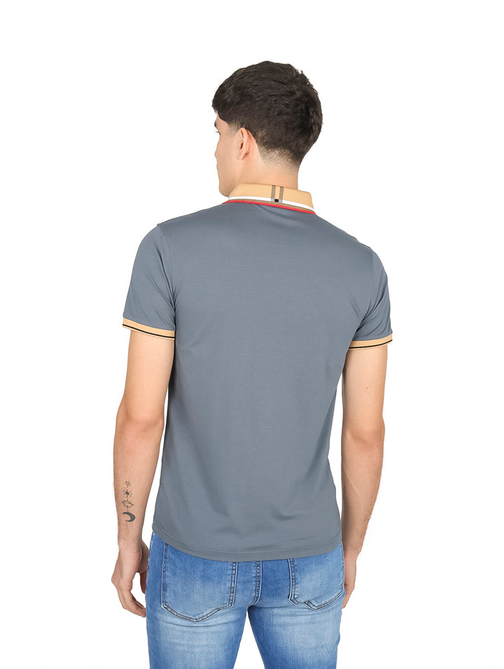 Hombre vistiendo una playera polo color gris con detalles en beige en el cuello y mangas.