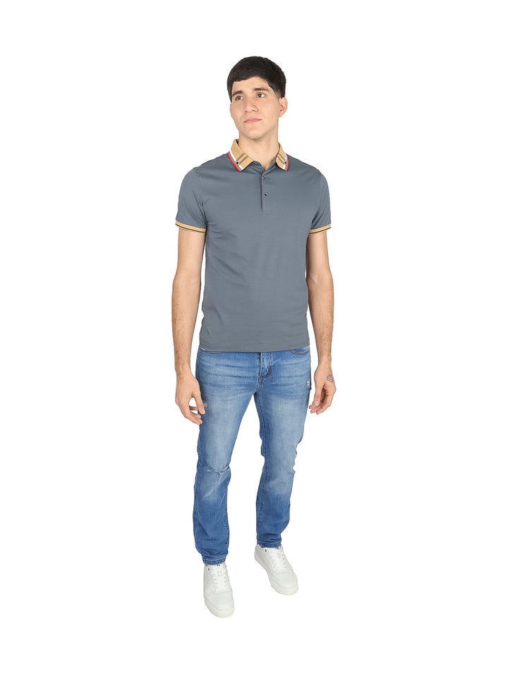 Hombre vistiendo una playera polo color gris con detalles en beige en el cuello y mangas.