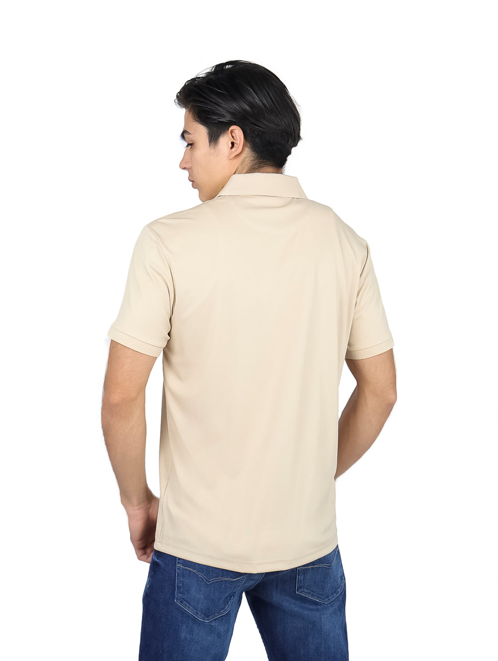 Hombre vistiendo una playera polo color beige con detalles decorativos en el pecho y un costado.