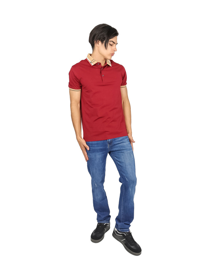 Hombre vistiendo playera polo color burgundy con cuello y bordes de manga en contraste color beige.