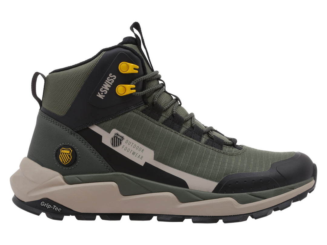 Bota K-Swiss color verde oliva y negro con suela beige para actividades outdoor.