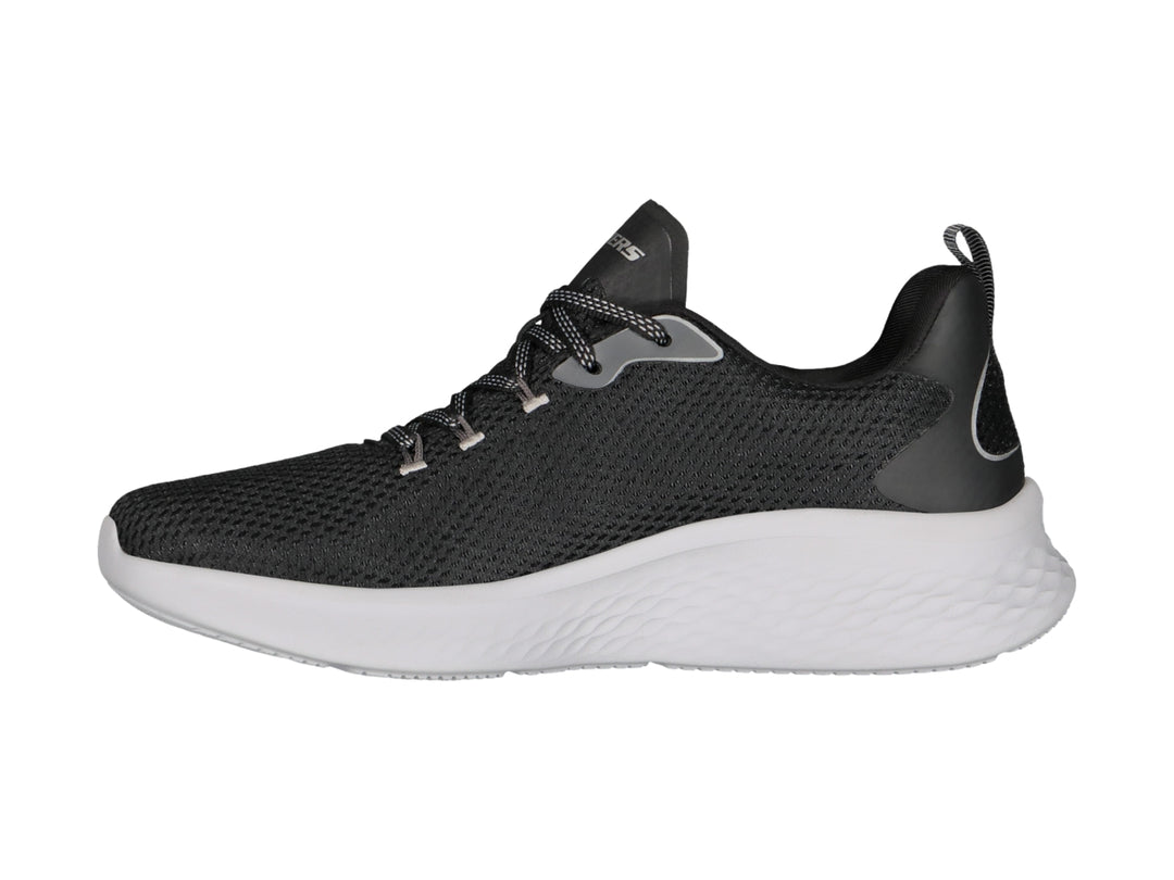 Tenis deportivos Skechers color negro con suela blanca y detalles en gris.
