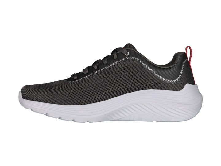 Tenis deportivos Skechers color gris con suela blanca y pequeña pestaña roja en el talón.
