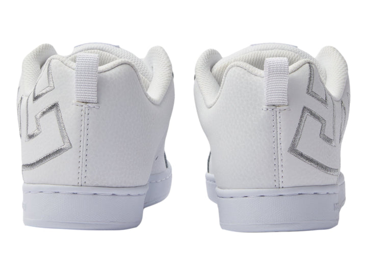 Tenis blancos DC Shoes con detalles gráficos plateados en el lateral y suela blanca.