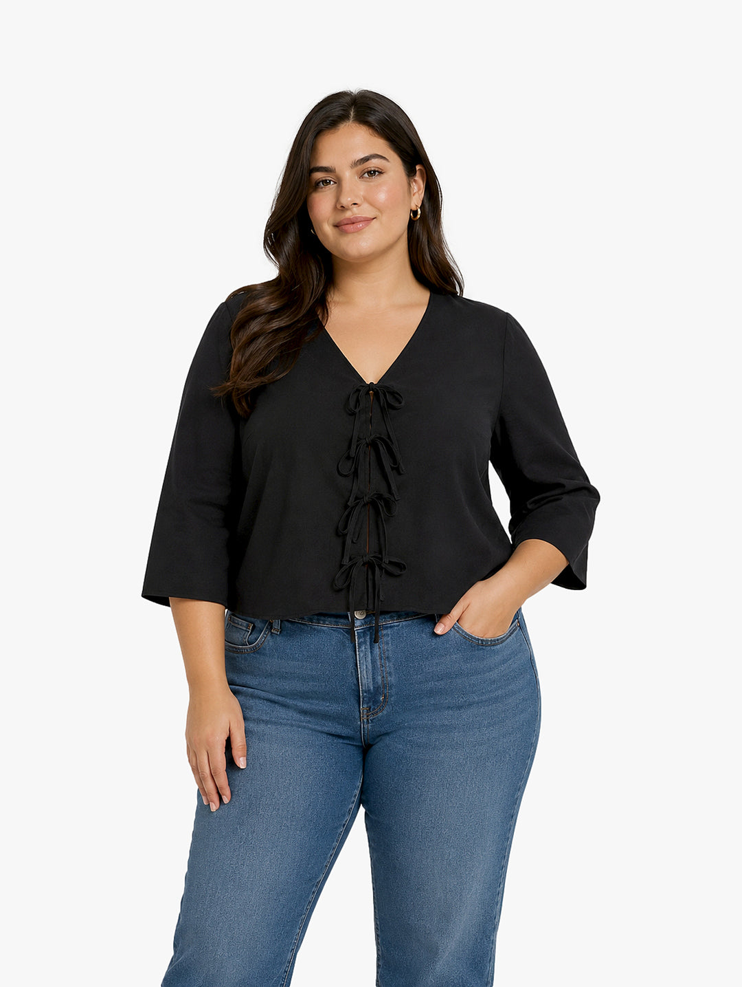 Mujer vistiendo blusa negra con escote en V y detalles de cordones frontales.
