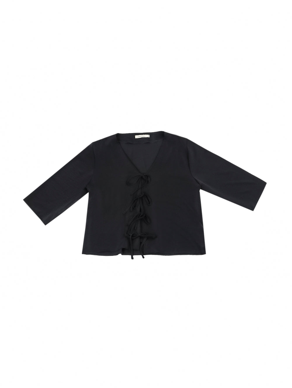 Mujer vistiendo blusa negra con escote en V y detalles de cordones frontales.