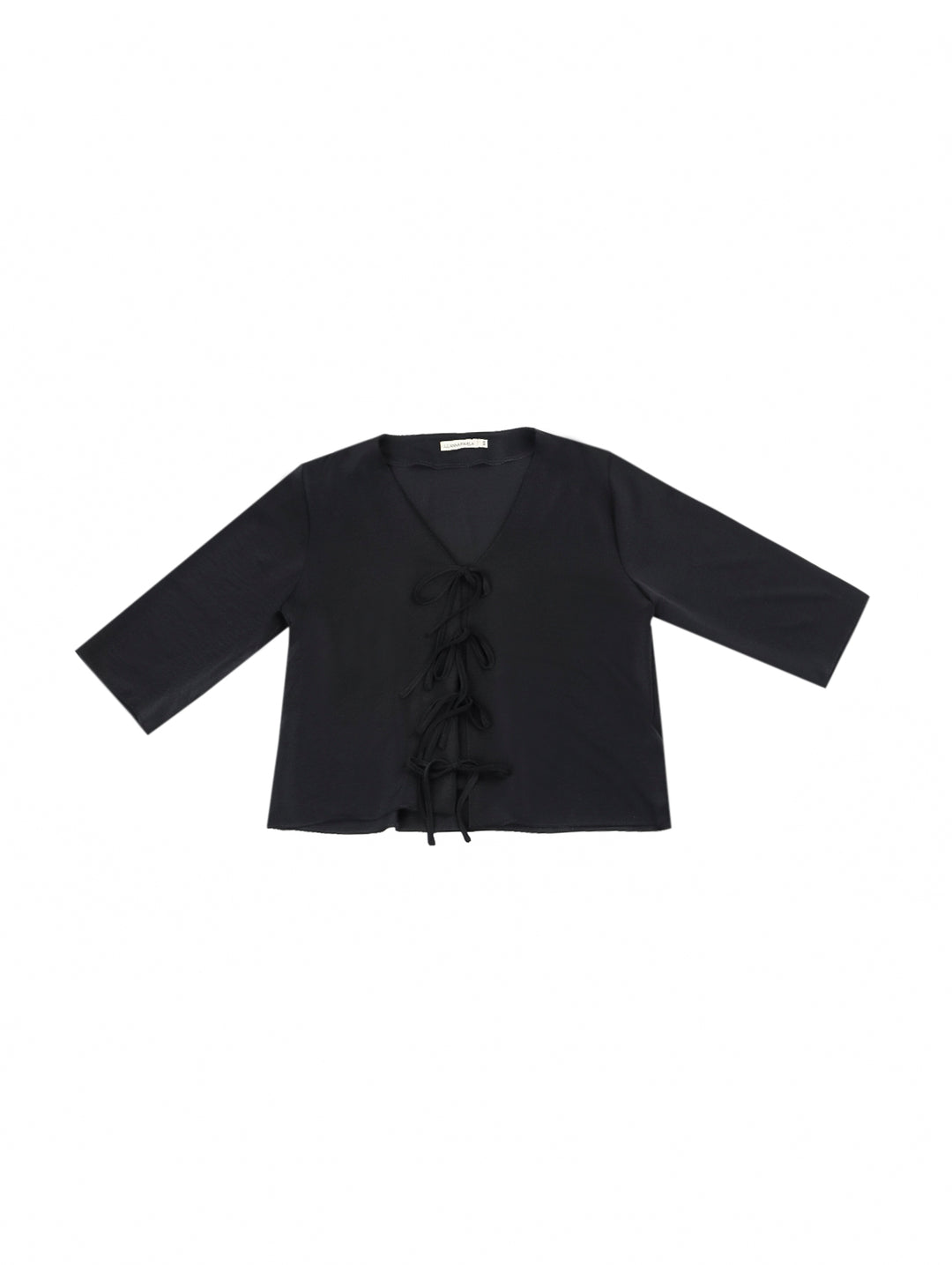 Mujer vistiendo blusa negra con escote en V y detalles de cordones frontales.
