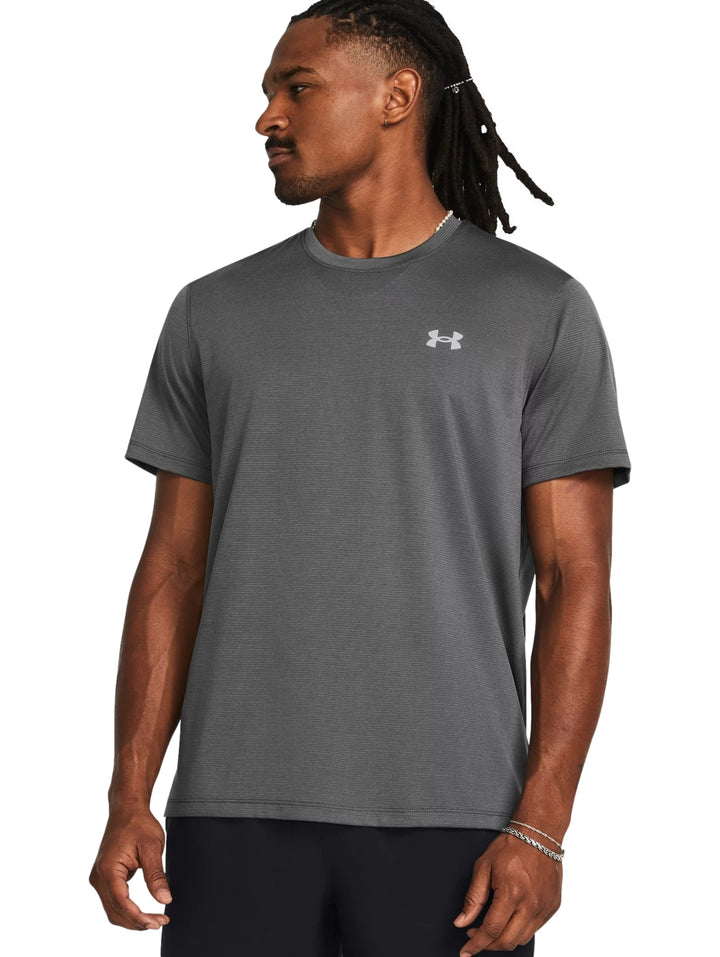 Hombre vistiendo una camiseta deportiva de manga corta color gris de la marca Under Armour.