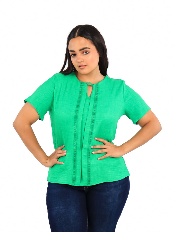Mujer vistiendo una blusa de color verde kelly con mangas cortas y cuello redondo.