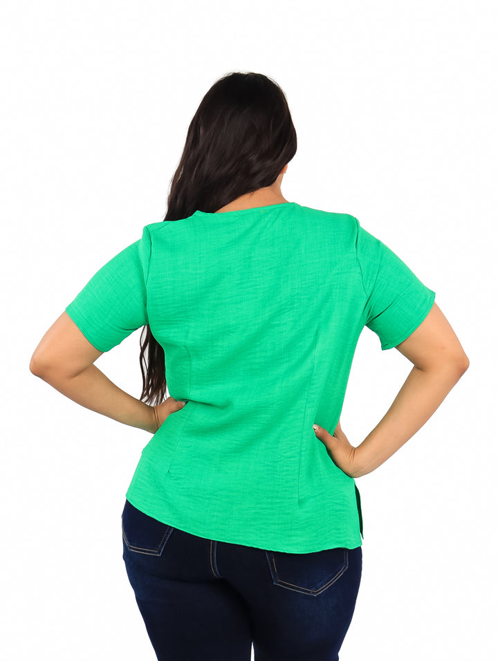 Mujer vistiendo una blusa de color verde kelly con mangas cortas y cuello redondo.