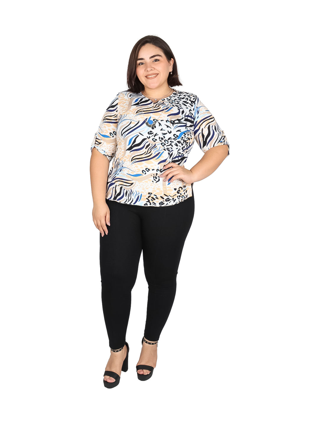 Mujer vistiendo blusa de manga corta con estampado multicolor abstracto en tonos azul, beige y negro.