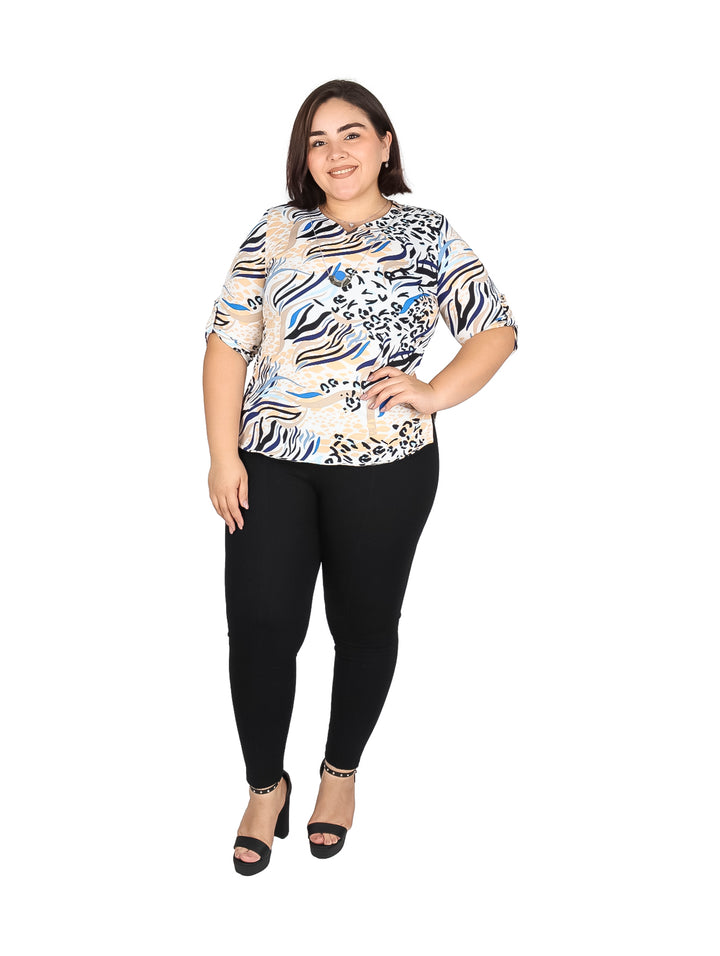 Mujer vistiendo blusa de manga corta con estampado multicolor abstracto en tonos azul, beige y negro.