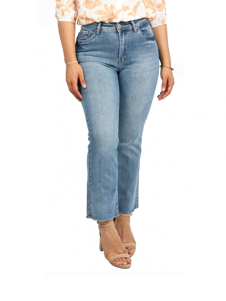Mujer vistiendo pantalones jeans azul claro con efecto stone wash y corte flare.