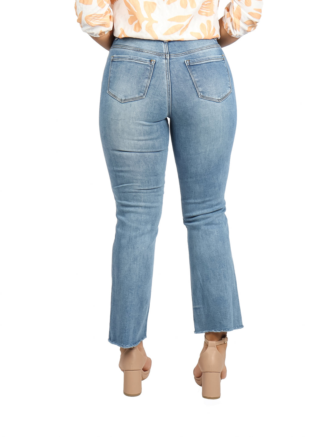 Mujer vistiendo pantalones jeans azul claro con efecto stone wash y corte flare.