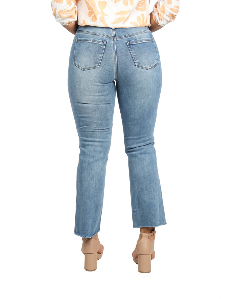 Mujer vistiendo pantalones jeans azul claro con efecto stone wash y corte flare.