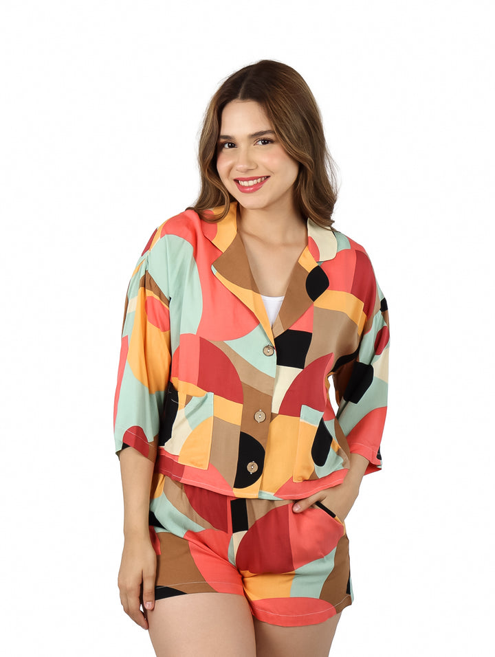 Mujer vistiendo blusa de manga corta con estampado geométrico multicolor.
