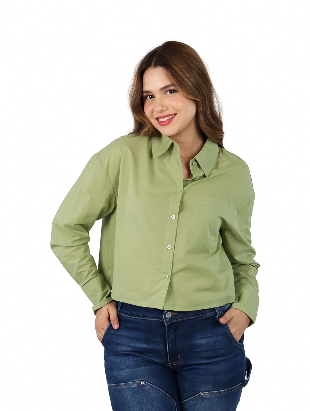 Mujer vistiendo una camisa verde de manga larga con botones y pantalones azules.