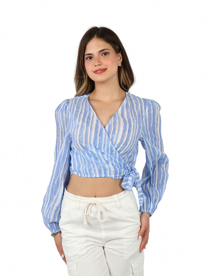 Mujer vistiendo blusa corta a rayas azules y blancas con nudo frontal y mangas largas.