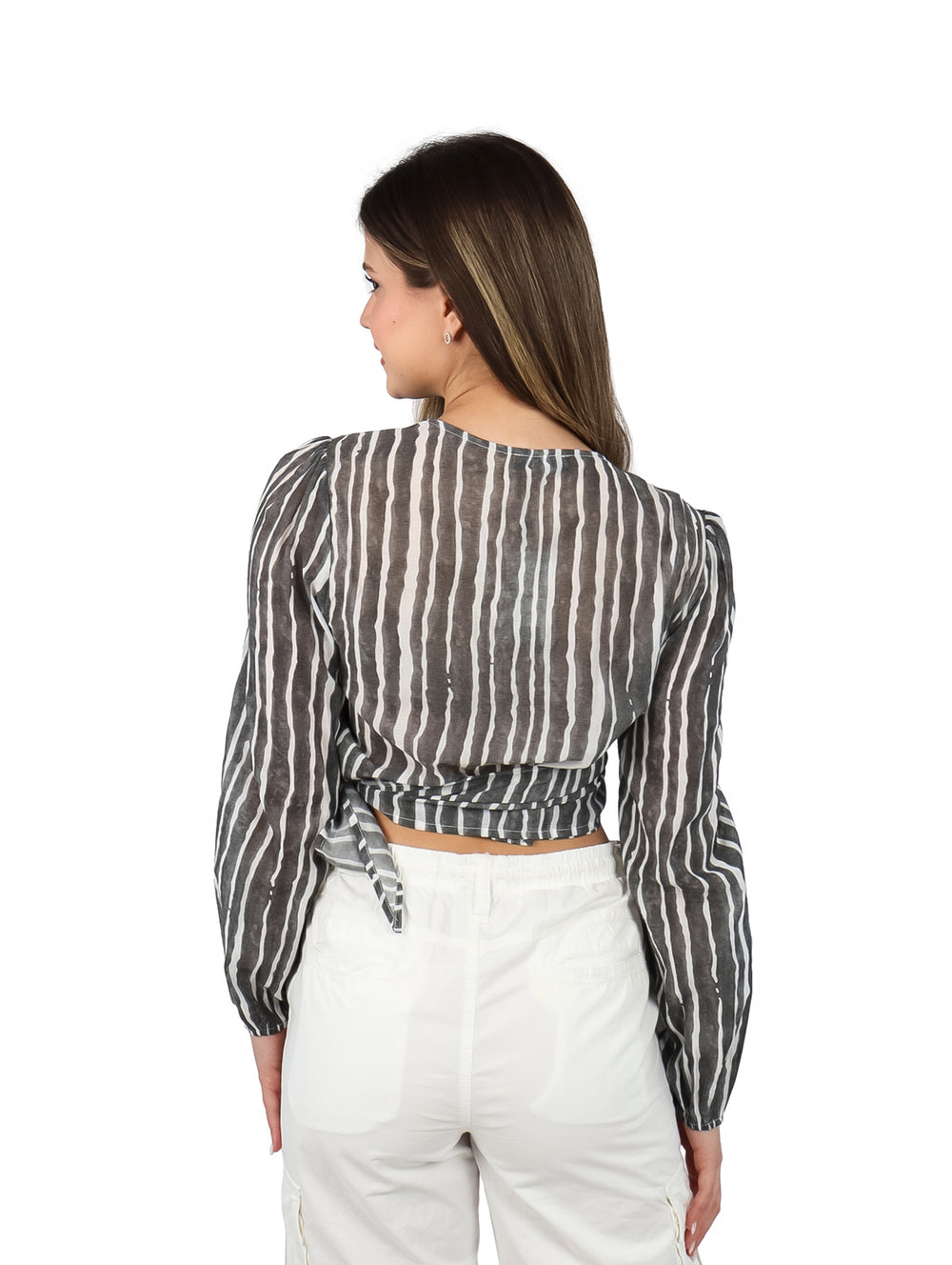 Mujer vistiendo blusa corta ATOK a rayas verticales blancas y negras con cuello en V y pantalones blancos.