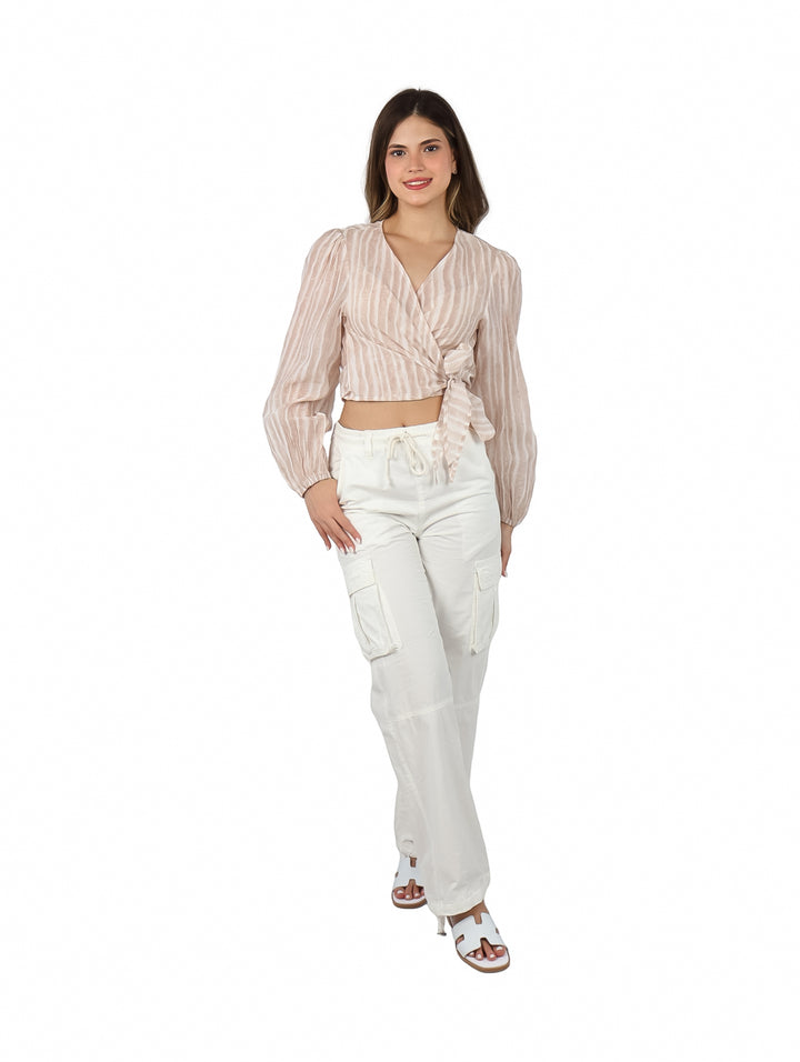 Mujer vistiendo blusa color marrón claro con rayas verticales y nudo frontal.
