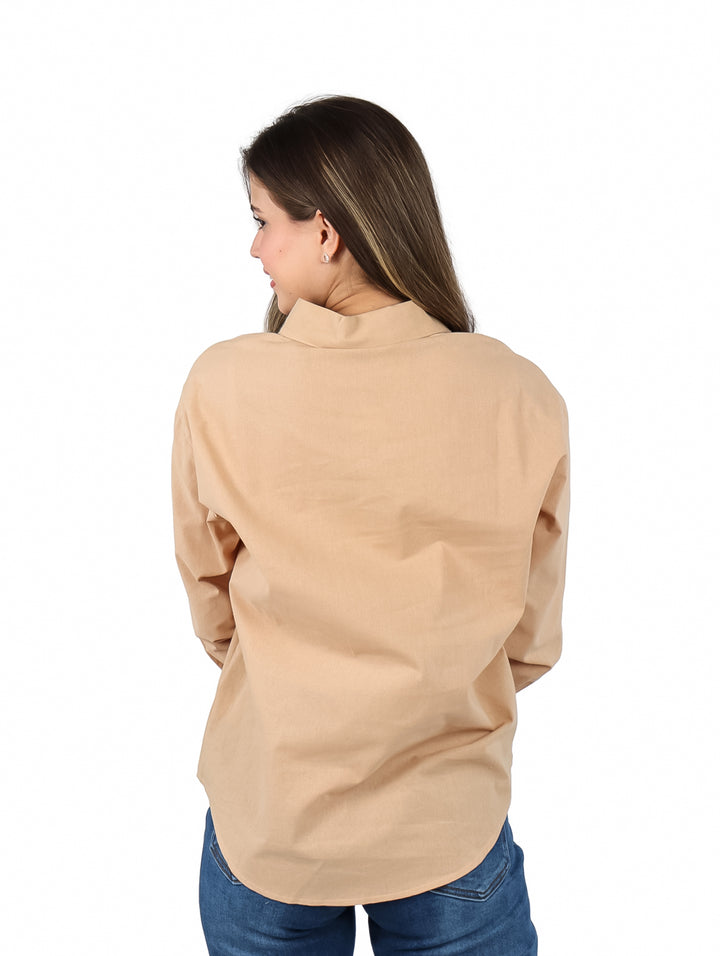 Mujer vistiendo una camisa de botones color marrón claro de manga larga.