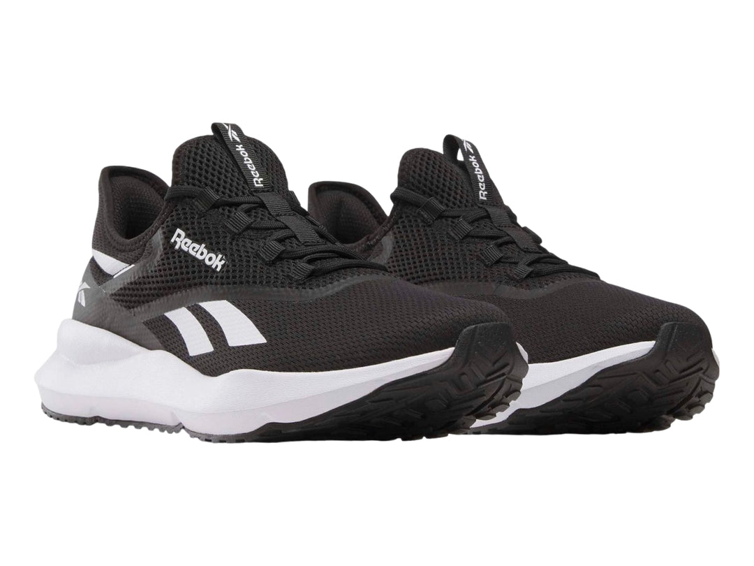 Tenis deportivos Reebok color negro con suela blanca y detalles laterales en blanco.