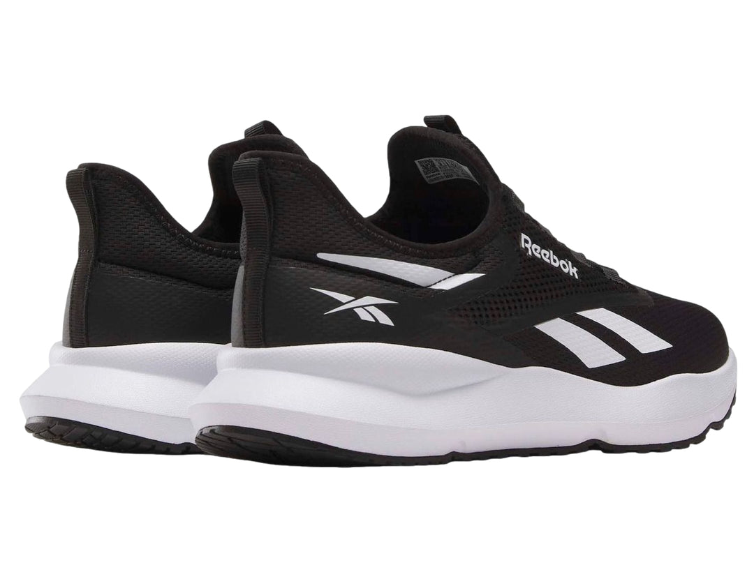 Tenis deportivos Reebok color negro con suela blanca y detalles laterales en blanco.