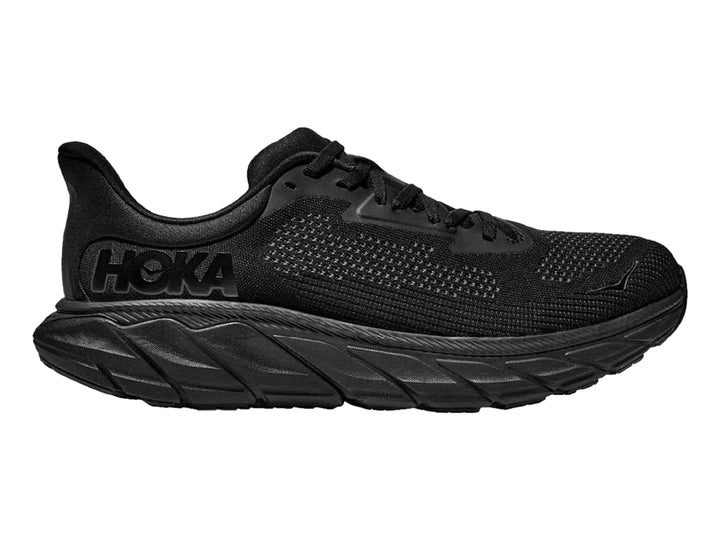 Tenis deportivos HOKA Arahi 7 en color negro total con suela ancha y malla transpirable.