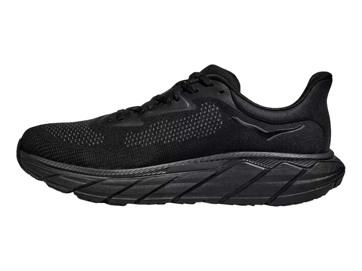 Tenis deportivos HOKA Arahi 7 en color negro total con suela ancha y malla transpirable.
