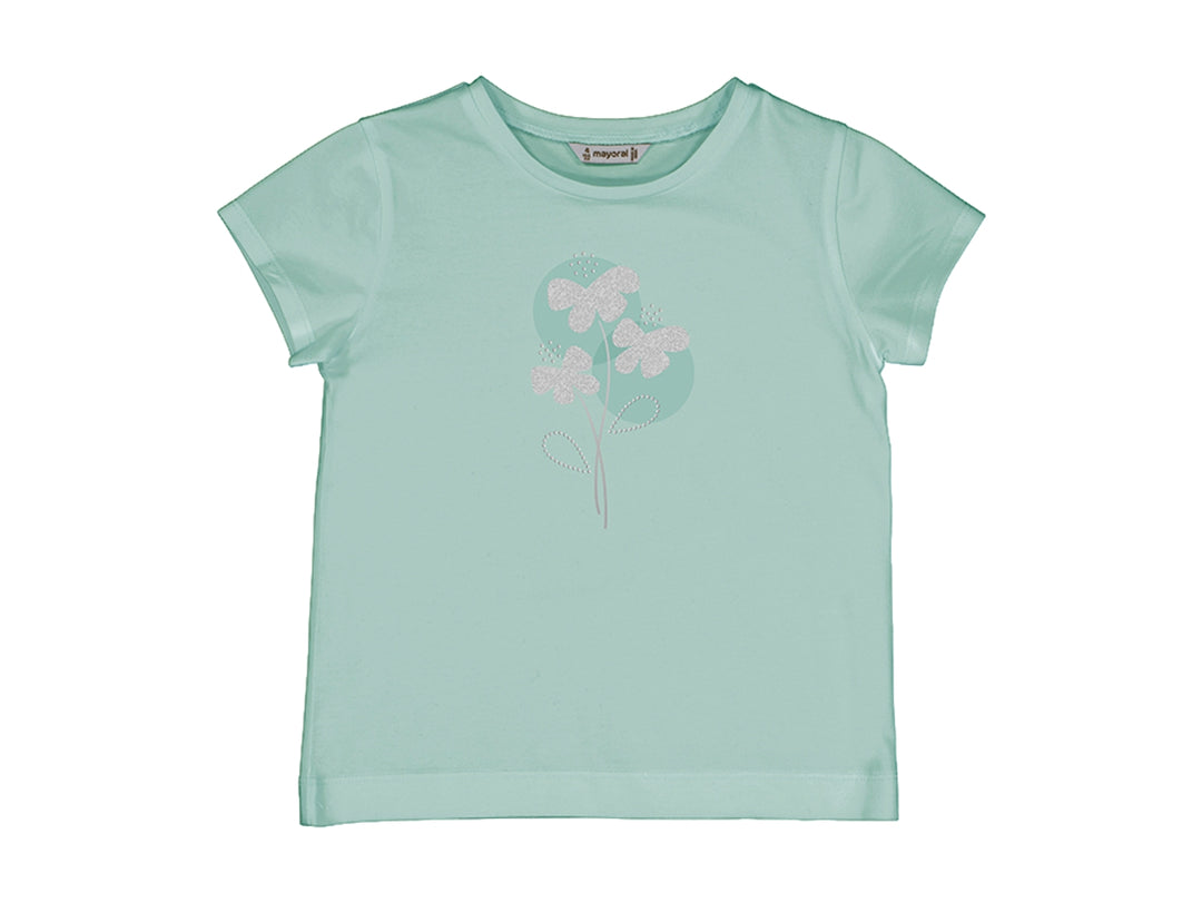 Camiseta básica color anís para niña con detalle floral brillante en el pecho.