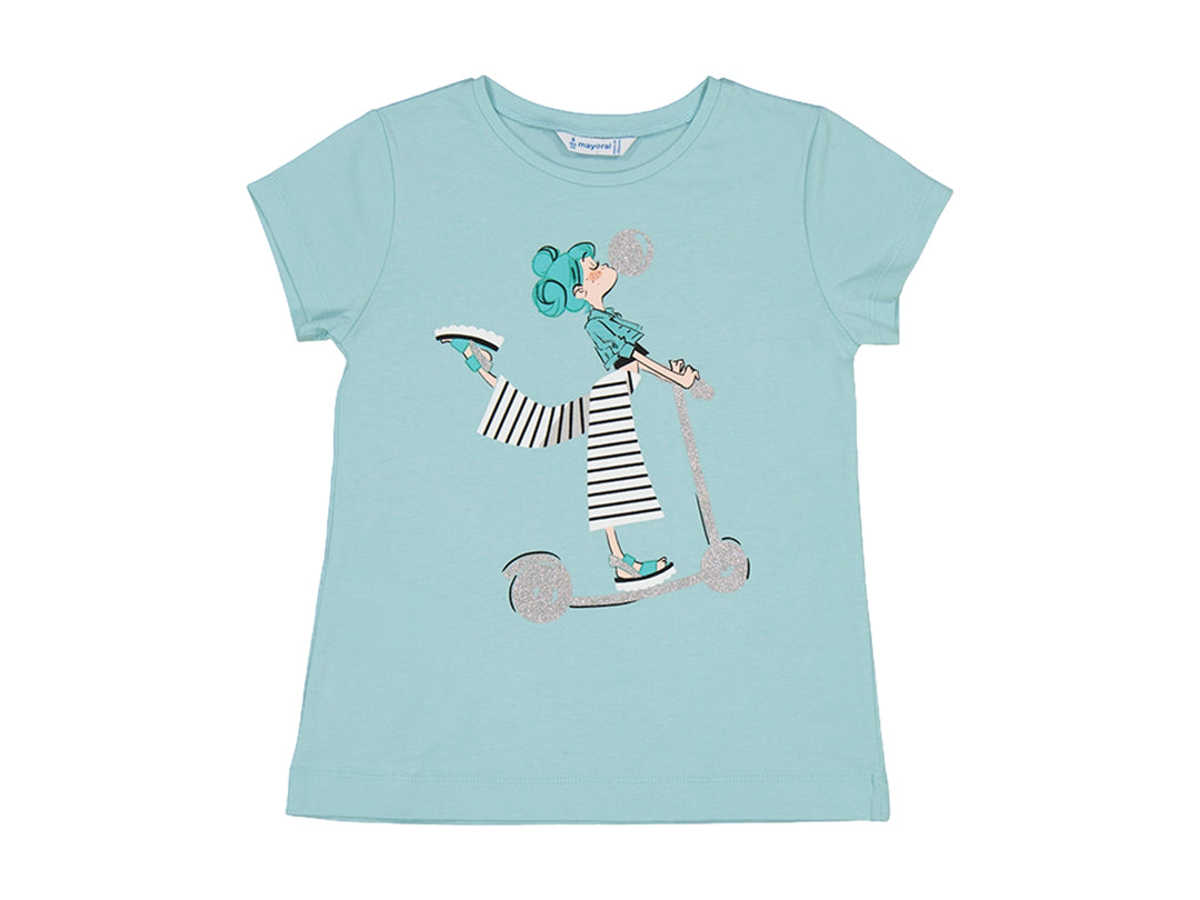 Camiseta color anís para niña con estampado frontal de una niña en patinete.