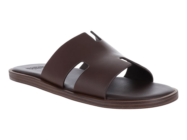 Sandalia Steve Madden de cuero color marrón con diseño de banda ancha y suela plana.