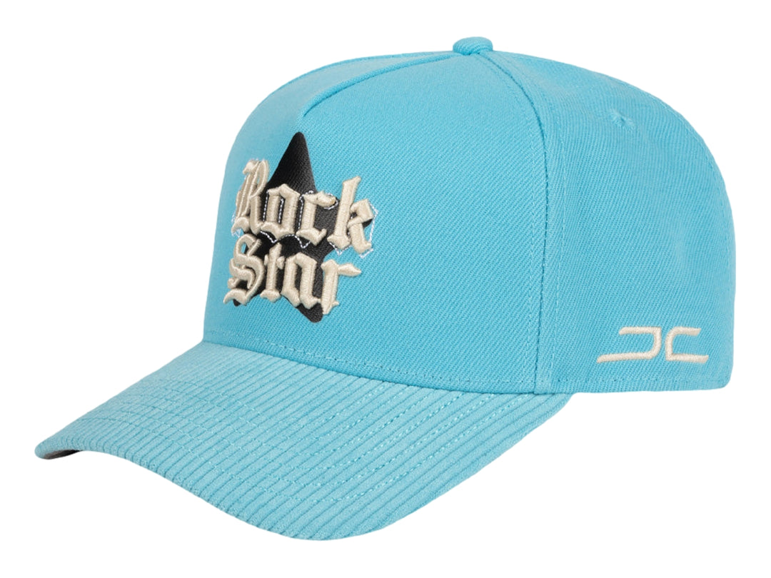 Gorra snapback color azul celeste con bordado frontal que dice Rock Star y logotipo JC en el lateral.