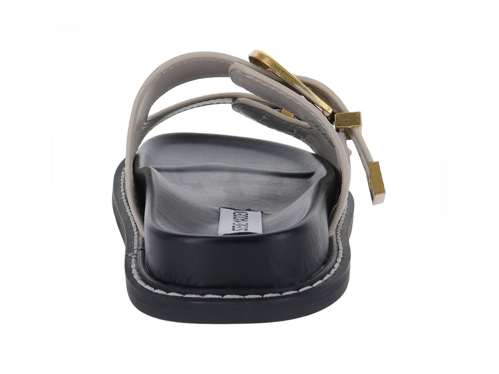 Sandalia plana Steve Madden color beige con dos correas, hebillas doradas y suela negra.