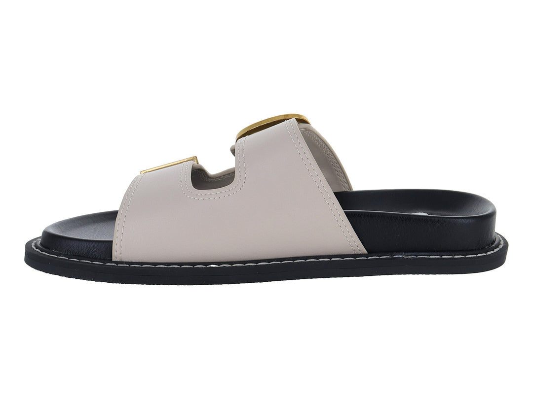 Sandalia plana Steve Madden color beige con dos correas, hebillas doradas y suela negra.