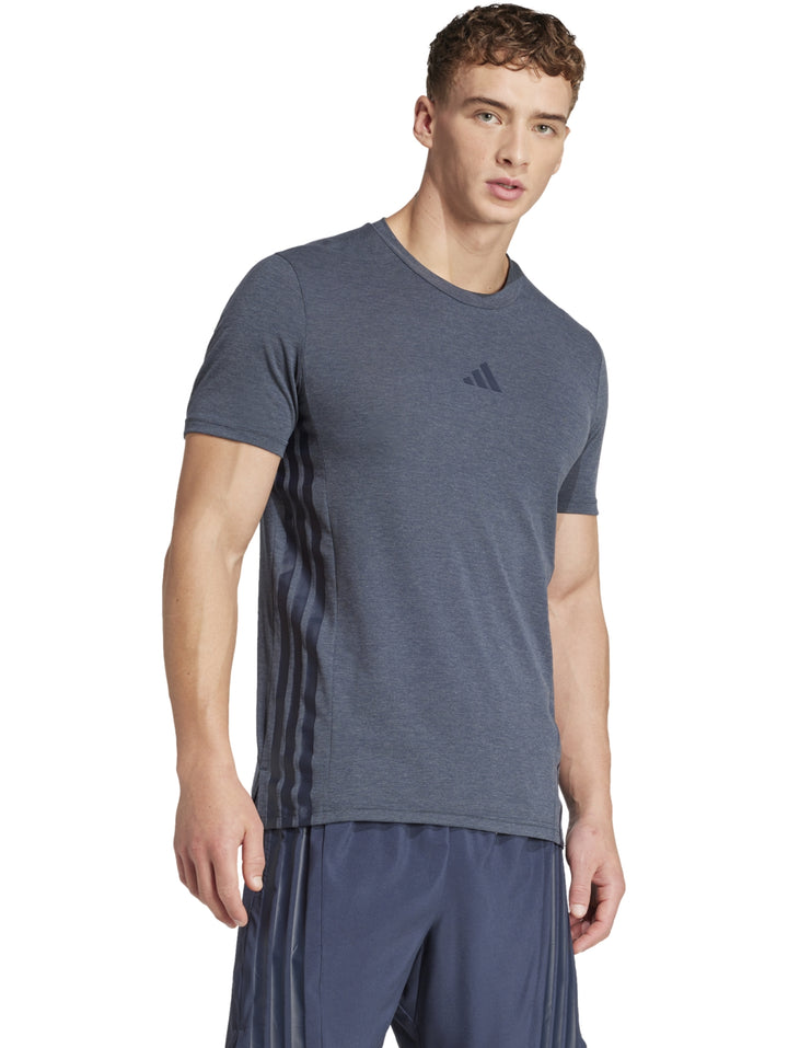 Hombre vistiendo una camiseta deportiva Adidas de color gris con cuello redondo y manga corta.