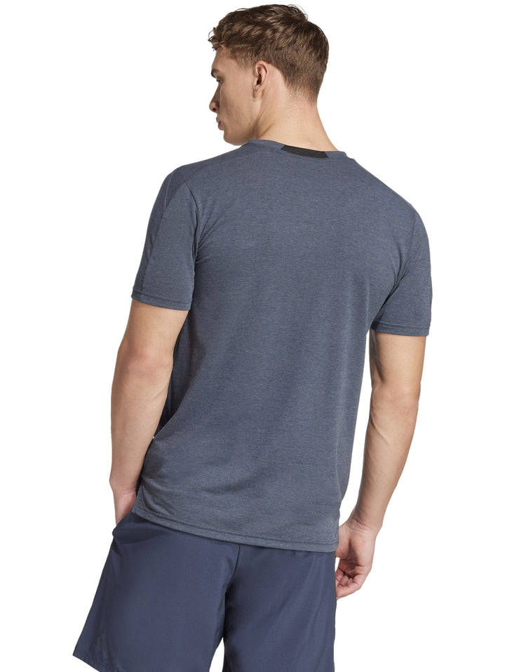 Hombre vistiendo una camiseta deportiva Adidas de color gris con cuello redondo y manga corta.